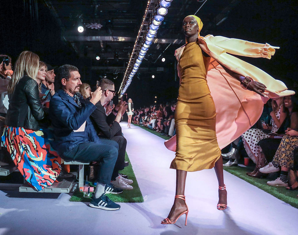 A model turns the corner of the runway